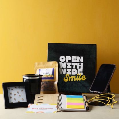 Brainstorm Boost Hamper : This Hamper Contains : Bamboo spiral notebook with sticky note and pen combo, Metal multi mobile stand with pen stand, Stainless steel coffee flask ,Mini photo frame, Premium mix dryfruit pack, Star cutting mdf piece for desk/tabletop, Work anniversary card, Flower bunch and Smile Black box