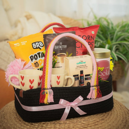 Duo_Delight_Hamper Contains:
Potato Popped Chips Pack,
Coffee Almond Laddoo (pack of 7),
Popped Corn Chips Pack,
Choco-chip Cookie Tin,
MCaffeine Body Detan Kit,
Set of Heartshape Ceramic 2 Cups,
Artificial Flower bunch,
Rectangular Woven Jute Basket With Loops