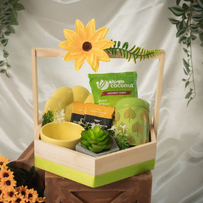  Sunshine_Bliss_Hamper Contains:
Baked Coconut Chips Pack,
Premium Instant Coffee Sachets [2],
Artificial Succulent Plant,
Printed Metal Tin,
Chocochips Cookies,
Sunflower Cup & Saucer set,
Artificial Flower bunch,
Pinewood Hexagon Hamper