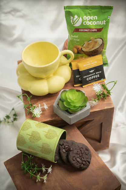  Sunshine_Bliss_Hamper Contains:
Baked Coconut Chips Pack,
Premium Instant Coffee Sachets [2],
Artificial Succulent Plant,
Printed Metal Tin,
Chocochips Cookies,
Sunflower Cup & Saucer set,
Artificial Flower bunch,
Pinewood Hexagon Hamper